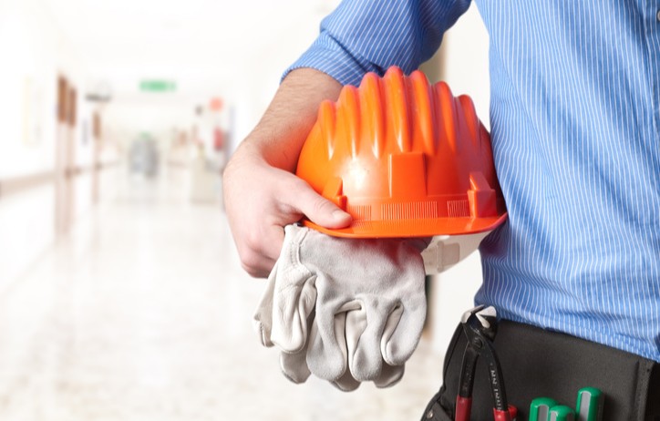 Ouvrier avec casque de chantier sous le bras