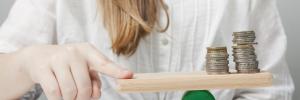 Femme faisant tenir des pièces en équilibre sur un morceau de bois avec son doigt